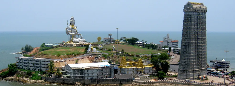 Murudeshwar Shiva statue shining in golden sunlight under clear blue sky during peak winter season