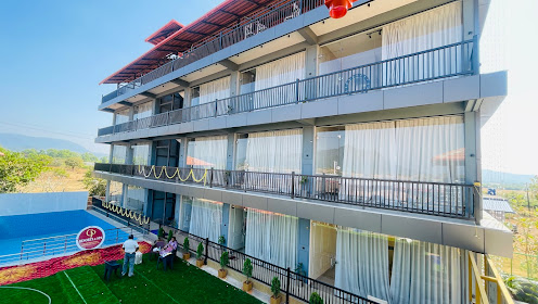 GP Resorts and Spa Murudeshwar - Modern building with swimming pool and greenery