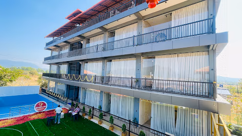 GP Resorts and Spa Murudeshwar - Modern building with swimming pool and greenery