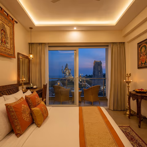 Hotel room with view of Murudeshwar Temple and Shiva statue at sunset