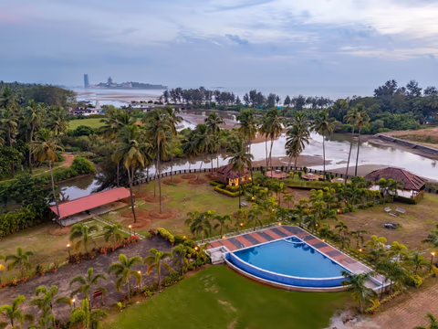 Pushkar Cottages Murudeshwar - aerial view of resort with swimming pool and Shiva Temple in background